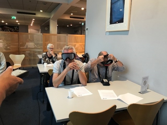 Een vrijwilliger met een VR-bril op leert door virtual reality hoe om te gaan met mensen met dementie 