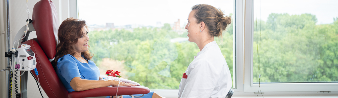 Foto van een zorgverlener en patiënt in gesprek