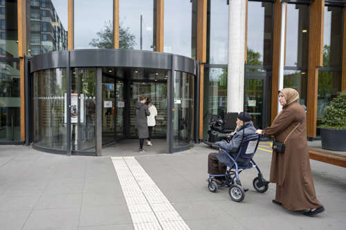 Patiënt in rolstoel en naaste voor entree OLVG West