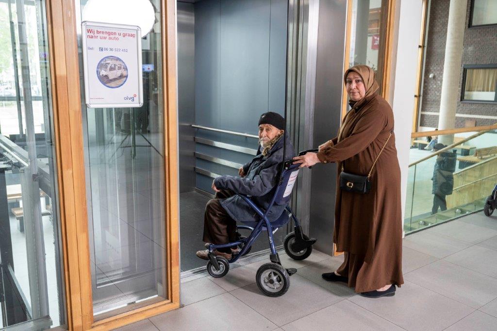 Patiënt en naaste voor de lift naar buiten